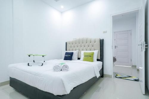 Tempat tidur dalam kamar di Urbanview Hotel Pondok Indah Pringsewu