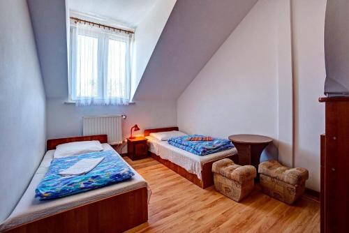 a bedroom with two beds and a table and chairs at Zajazd pod Sosnami in Berezka