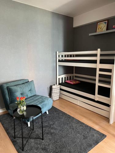 a room with a bunk bed and a chair and a table at Apartament Przy Kawczej in Międzyzdroje
