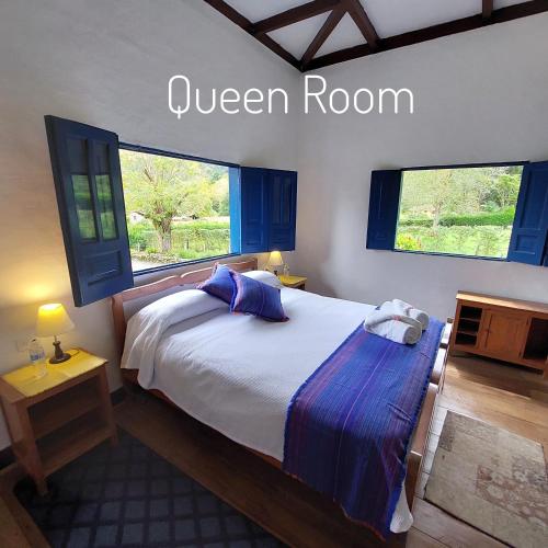 a bedroom with a white bed with blue pillows at Reserva Guadalajara - Cocora Valley in Salento