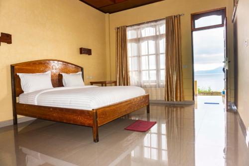 - une chambre avec un lit et une grande fenêtre dans l'établissement Reggae Guest House, à Tuk Tuk