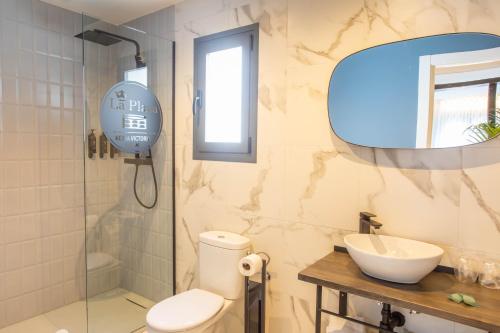 a bathroom with a toilet and a sink and a mirror at Reina Victoria La Plaza in Alicante