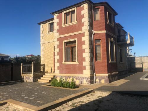 a red brick building with a balcony on top at Goradil Beach in Baku