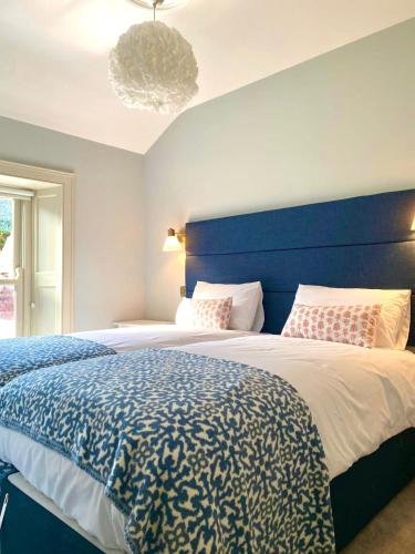 a bedroom with a large bed with a blue headboard at The Glen House in Kinsale