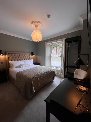 a bedroom with a bed and a table and a lamp at The Glen House in Kinsale