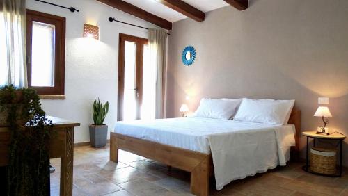 - une chambre avec un lit doté de draps et d'oreillers blancs dans l'établissement Villa Mameli b&b, à Rena Majore