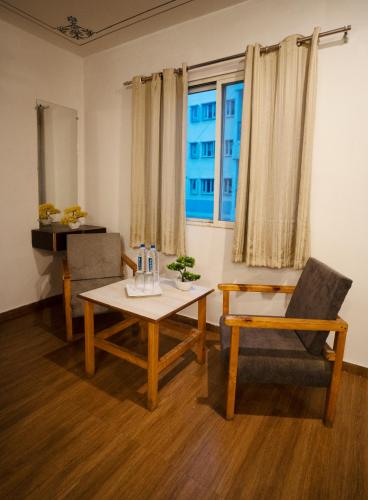 a living room with a table and chairs and a window at Tripli Hotels Arunoday Palace in Udaipur