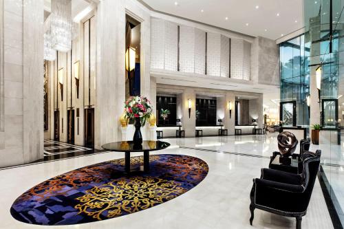 a lobby with a table and chairs in a building at Grande Centre Point Hotel Terminal21 in Bangkok