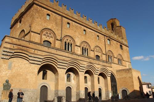 a large brick building with people standing in front of it at Appartamenti Pistrella in Orvieto