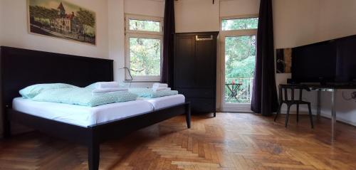 una camera da letto con un letto con lenzuola bianche e due finestre di Central Pension a Duisburg