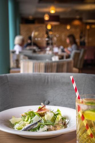 a plate of food on a table with a drink at Wivenhoe House Hotel in Colchester