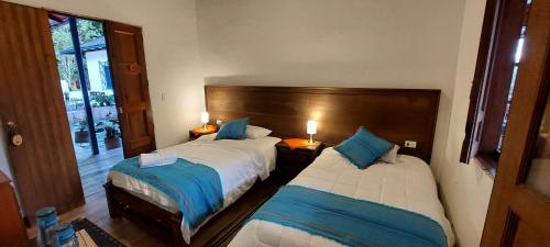 a bedroom with two beds with blue pillows at Reserva Guadalajara - Cocora Valley in Salento