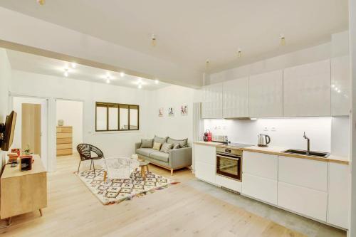 a kitchen and living room with a couch and a table at Central & Stylish renovated Parisian apt / 6-8 guests in Paris