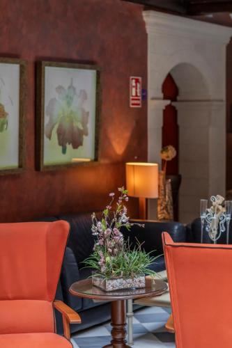 a living room with orange chairs and a table at Hotel Soho Boutique Vistahermosa in El Puerto de Santa María