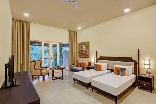 a bedroom with a bed and a living room at Gateway Coorg in Madikeri