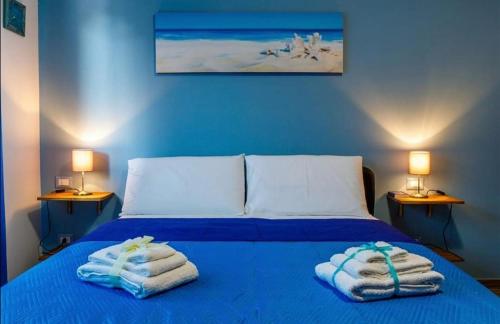 Un dormitorio con una cama azul con toallas. en B&B Da Antonella en Troina