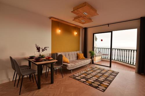 salon z kanapą i stołem w obiekcie The view will convince you! w mieście Puerto de Santiago