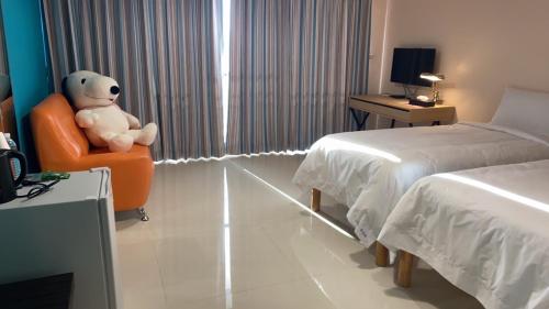 a teddy bear sitting in a chair in a bedroom at Shui Shang Yuan Homestay in Magong