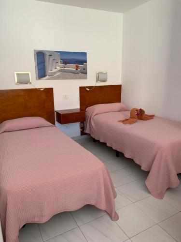 a room with two beds and a tv on the wall at Casa Torres in San Bartolomé de Tirajana