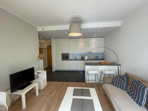 salon z kanapą i kuchnią w obiekcie Home3city Nadmorski Dwór w Gdańsku