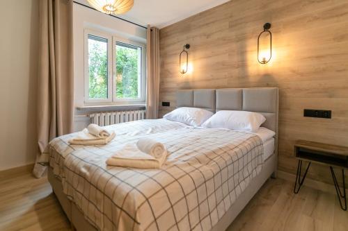 ein Schlafzimmer mit einem großen Bett mit Handtüchern darauf in der Unterkunft Wisła - Centrum, Apartament z Wiślaczkiem - Dream Apart in Wisła