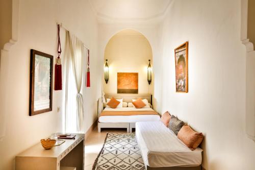 a bedroom with a bed and a couch in a room at Hotel & Spa Riad Al Jazira in Marrakech