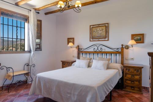 1 dormitorio con cama y ventana en Cortijo La Presa, en Priego de Córdoba