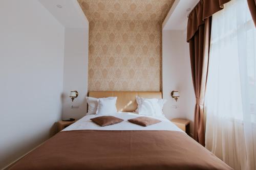 a bedroom with a large bed with two pillows at Hotel Restaurant Park in Miercurea-Ciuc