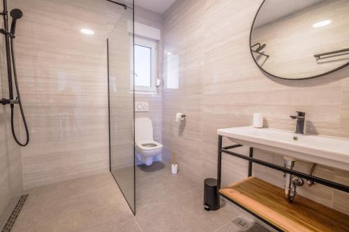 een badkamer met een toilet, een wastafel en een spiegel bij Apartment House Vista in Crikvenica