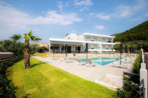 a large building with a swimming pool and a resort at The Angeliki Boutique Hotel in Skala Rachoniou