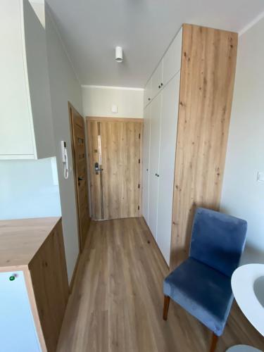 a small apartment with a blue chair in a room at Apartamenty Białe nad jeziorem Białym in Augustów