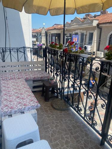 a patio with two benches and an umbrella at Galeb Apartment Ohrid in Ohrid