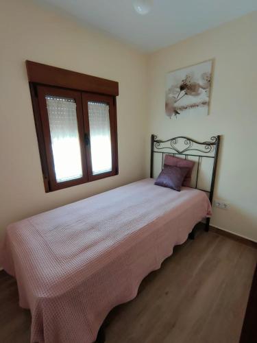 a bedroom with a bed in a room with two windows at Casa Valentín in Casillas