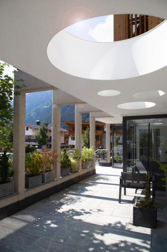a lobby of a building with potted plants at Hotel & Suites Glück Auf in Mayrhofen
