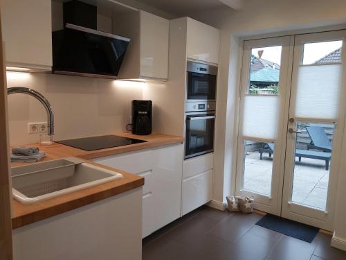 a kitchen with a sink and a stove top oven at Huus Utspann in Tönning