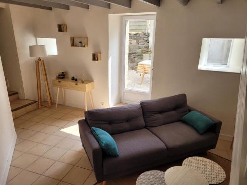 a living room with a couch and a window at Le Penty du Peulven in Plestin-les-Grèves