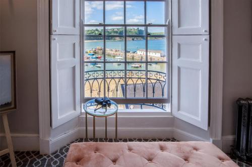 a room with a window with a view of a city at Gwynne House - 6 Bed Holiday Home - Tenby Harbour in Tenby