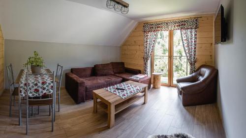 a living room with a couch and a table at Ostoja Gorce in Nowy Targ