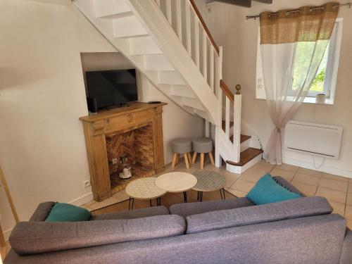a living room with a couch and a tv at Le Penty du Peulven in Plestin-les-Grèves