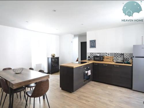 une cuisine et une salle à manger avec une table et un réfrigérateur dans l'établissement Grand appartement LOFT Lannion centre T4, à Lannion