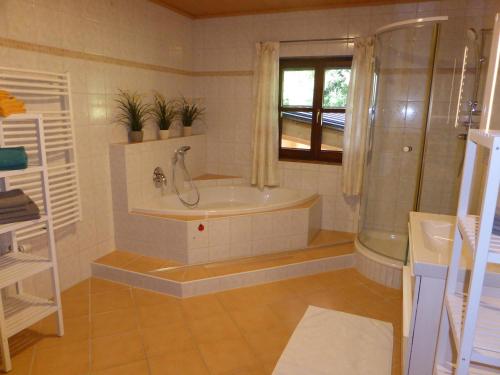 Haus Hütter في ألتاوسي: حمام مع حوض استحمام ودش ومغسلة