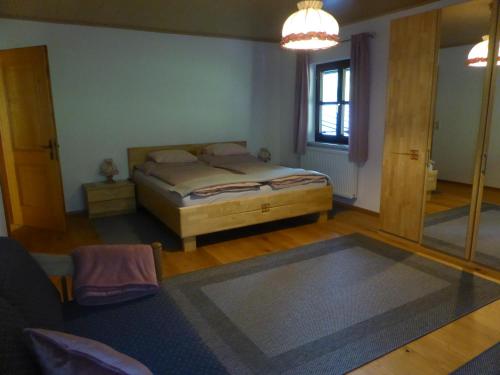 Haus Hütter في ألتاوسي: غرفة نوم بسرير ومرآة كبيرة