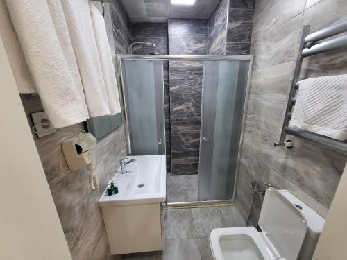 a bathroom with a shower and a sink and a toilet at Panorama-Madinah-ZamZam -Halal Hotels Group in Baku