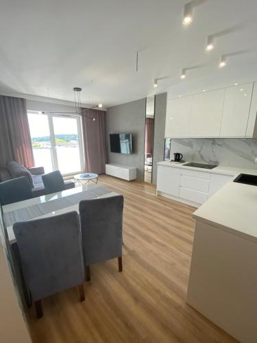a large kitchen and living room with a table at Apartamenty Białe nad jeziorem Białym in Augustów