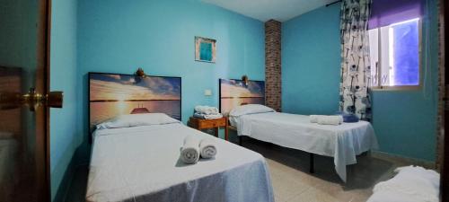 2 łóżka w pokoju z niebieskimi ścianami w obiekcie Tinache Beach 103 Maspalomas w mieście San Bartolomé