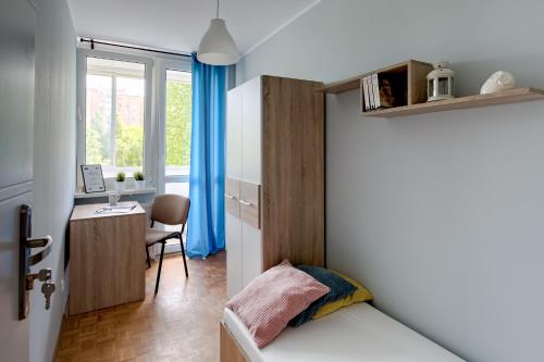 a bedroom with a bed and a desk and a window at SuperApart Krzywoń 8 ROOMS in Warsaw