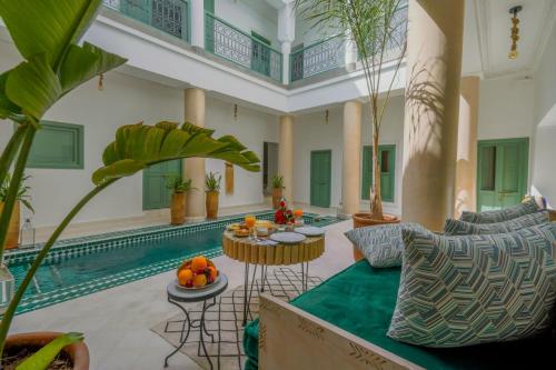 ein Wohnzimmer mit einem Pool und einem Tisch mit Obst darauf in der Unterkunft Riad Trésor Marrakech in Marrakesch