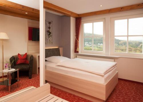 a hotel room with a bed and a window at Hotel Zum weißen Stein in Kirchen
