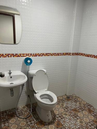 a bathroom with a toilet and a sink at อาร์ทู R2 RongKhun in Chiang Rai