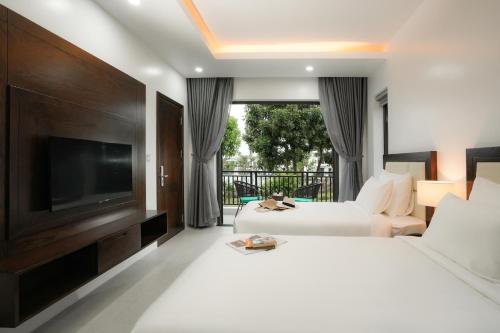 a bedroom with two beds and a flat screen tv at DAD Resort Phú Quốc in Phú Quốc